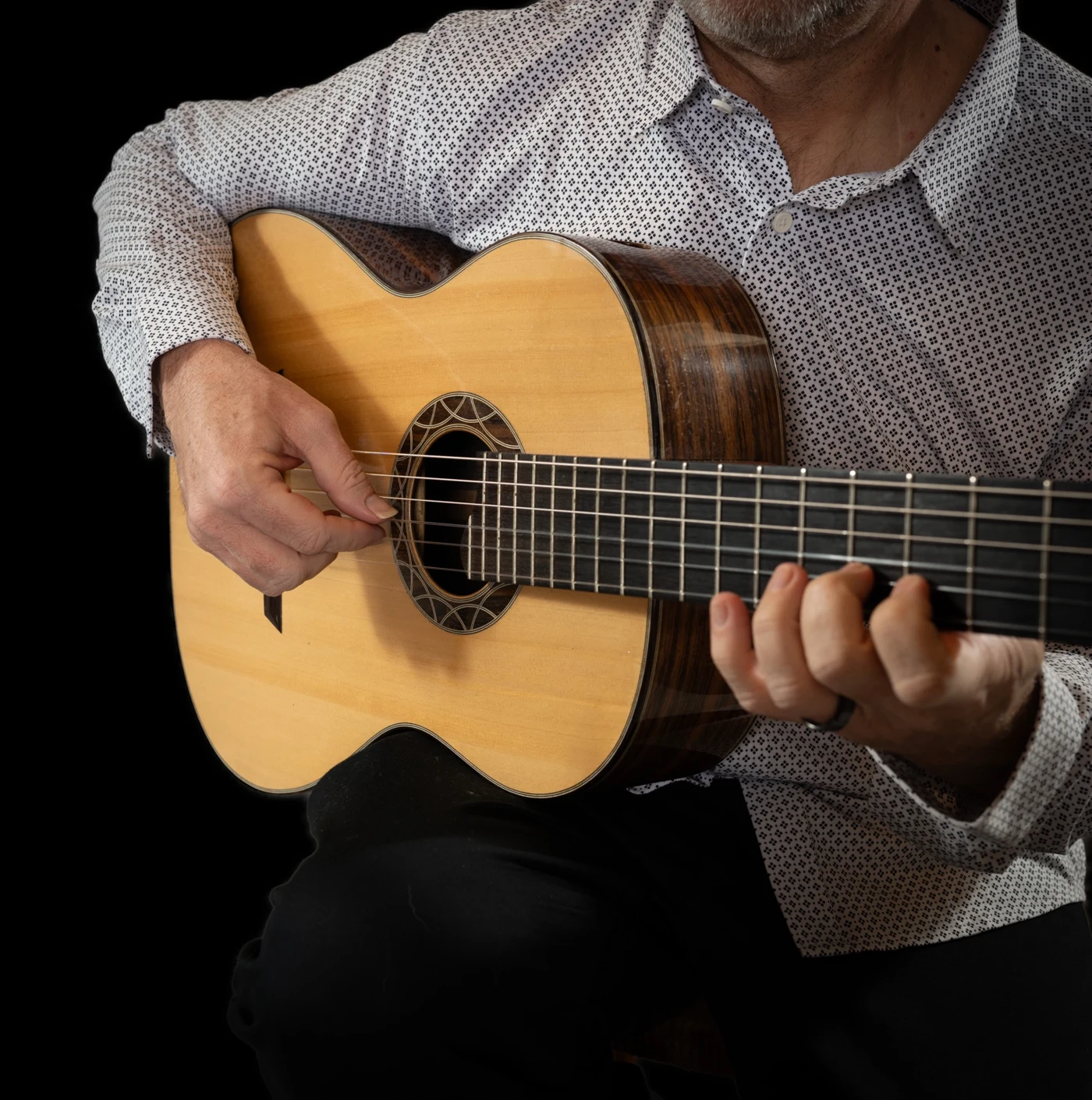 Close-up of Christopher playing classical guitar